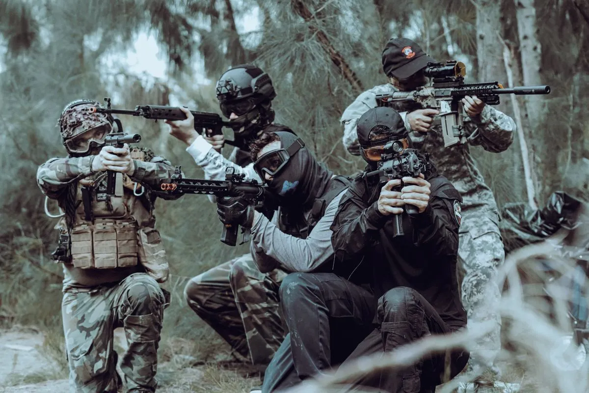 A team of airsoft players in camouflage and masks in woodland