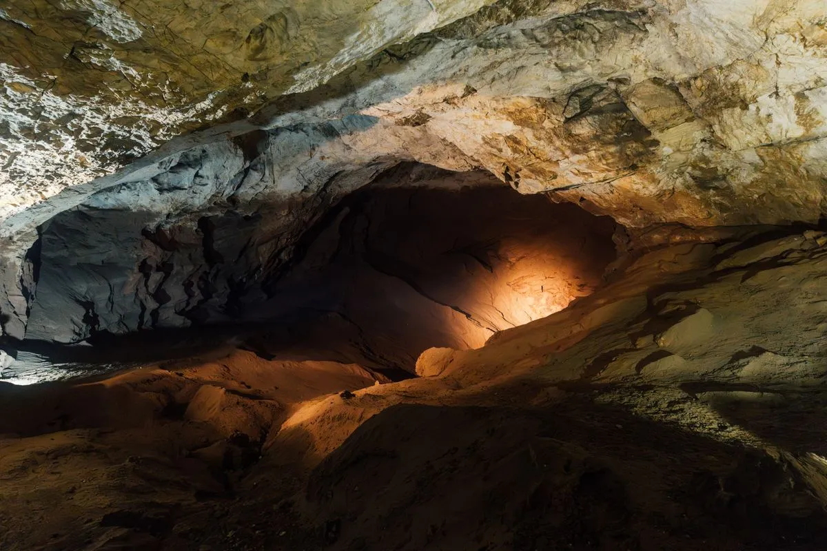 Rock formations inside a cave, lit by a warm glow.
