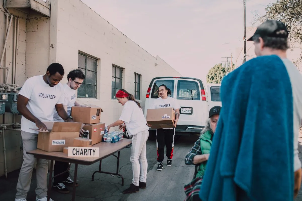 Group of volunteers organizing donations outside.