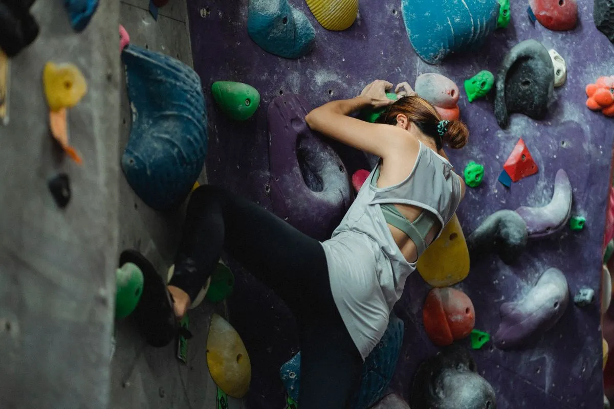A climber training on a colourful bouldering wall