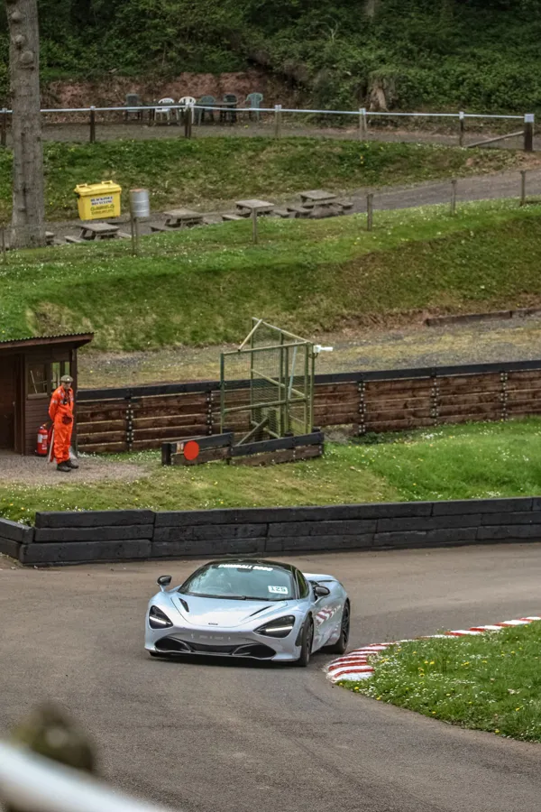 A McLaren sports car racing around a track curve