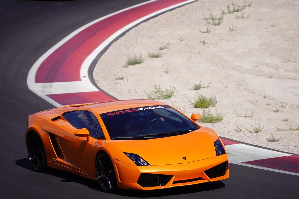 An orange sports car racing on a circuit.