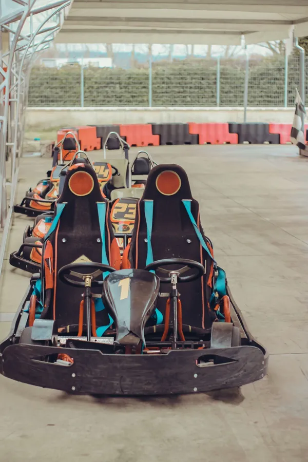 Line of colorful go-karts ready for racing on an empty track.
