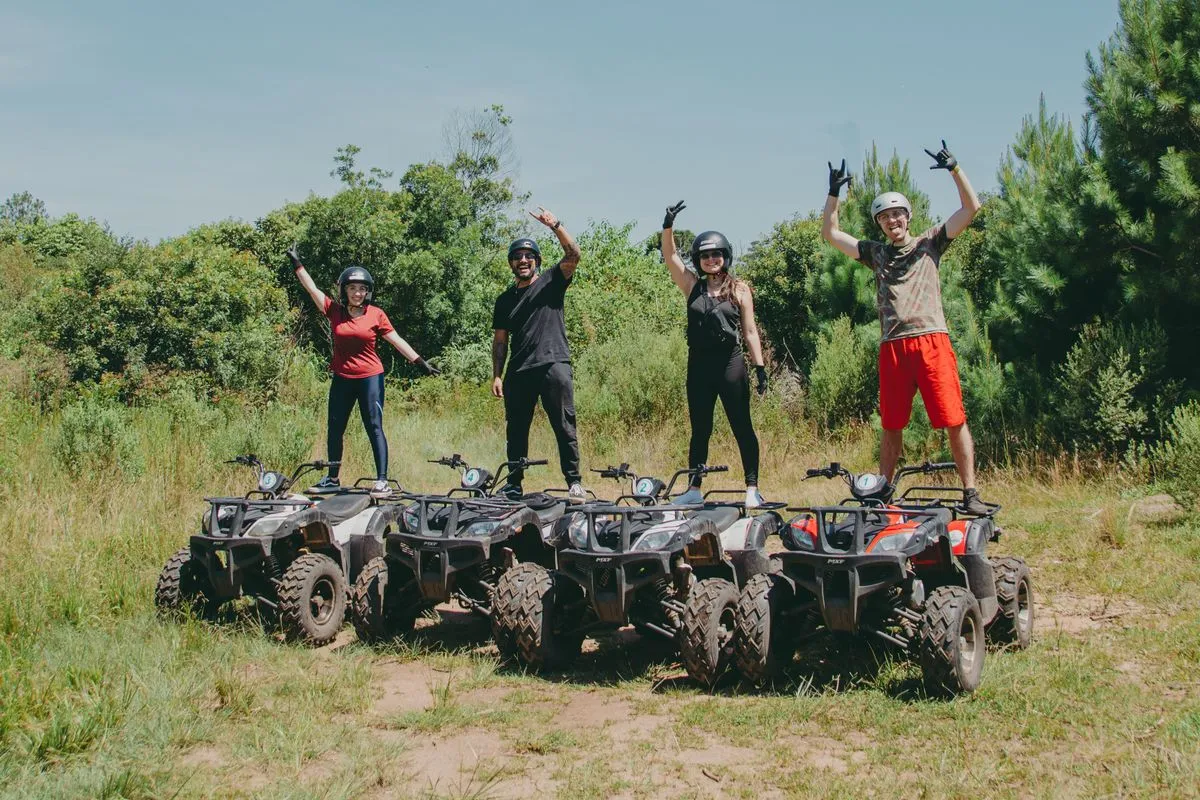 A group of friends with their quad bikes on a grassy track
