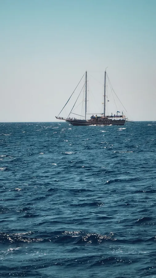 A large sailboat navigates the open sea.