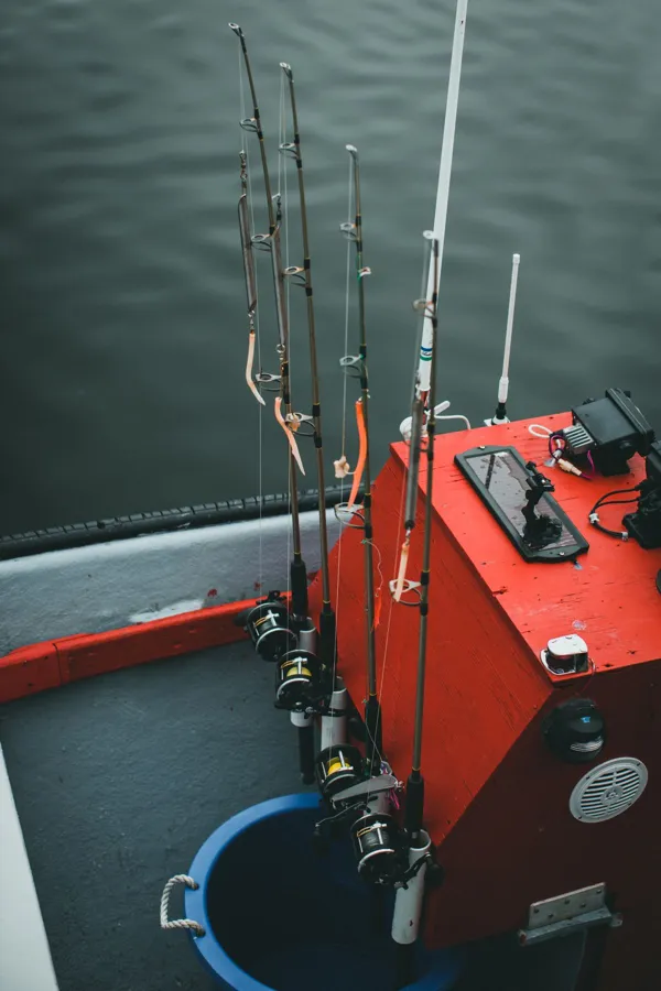 Fishing rods on a red boat over calm water