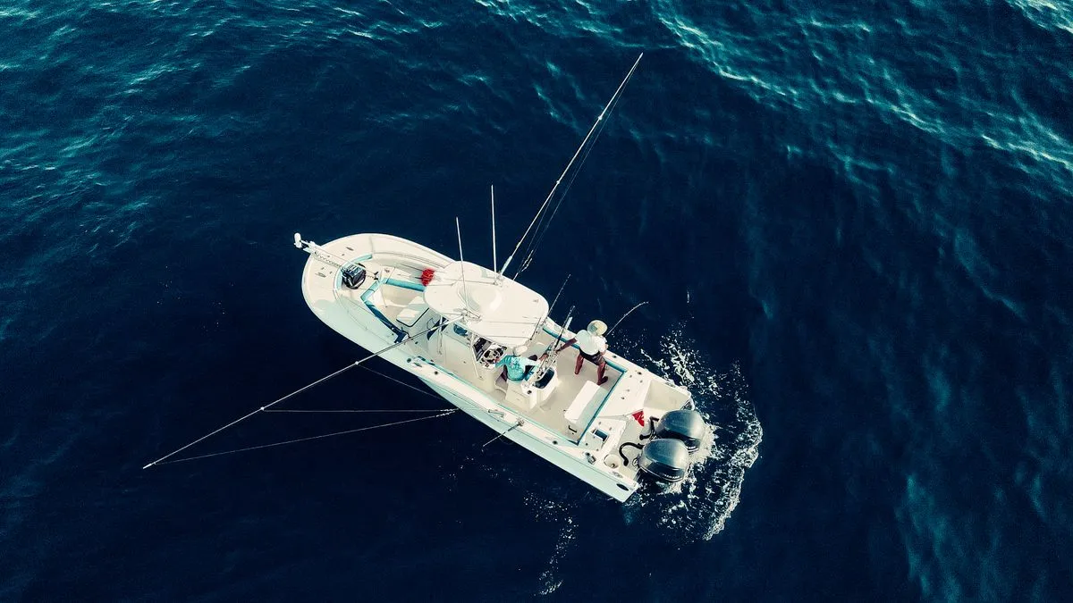 A fishing boat seen from above on dark blue ocean water