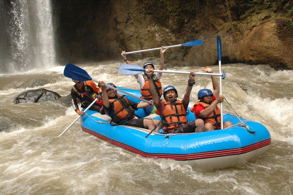 Group enjoying a thrilling white water rafting adventure amidst wide waterfalls and rapids.